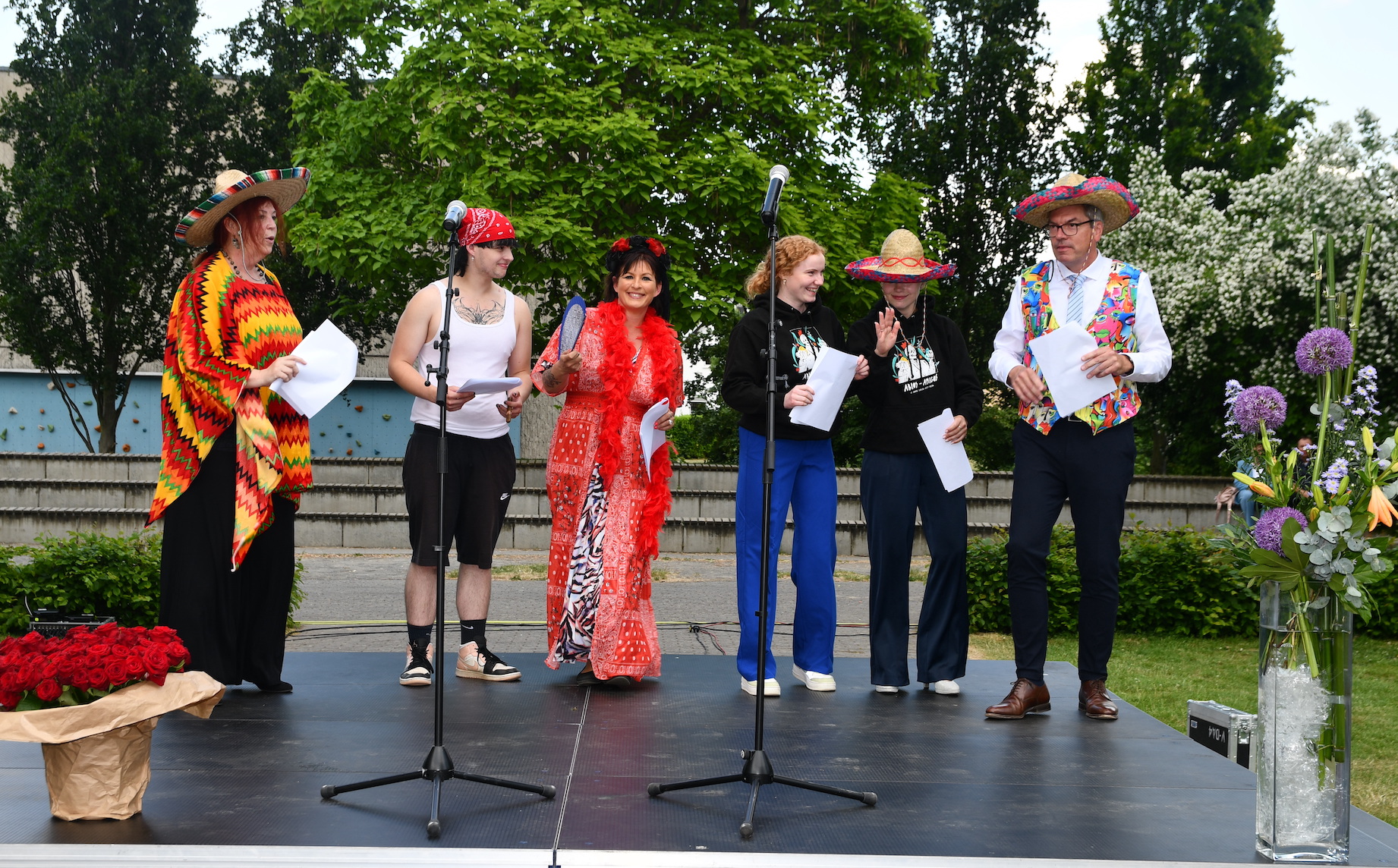 Schulleiter, Schüler:innen, Mutter, Stufenleiterin mit Sombreros auf der Bühne