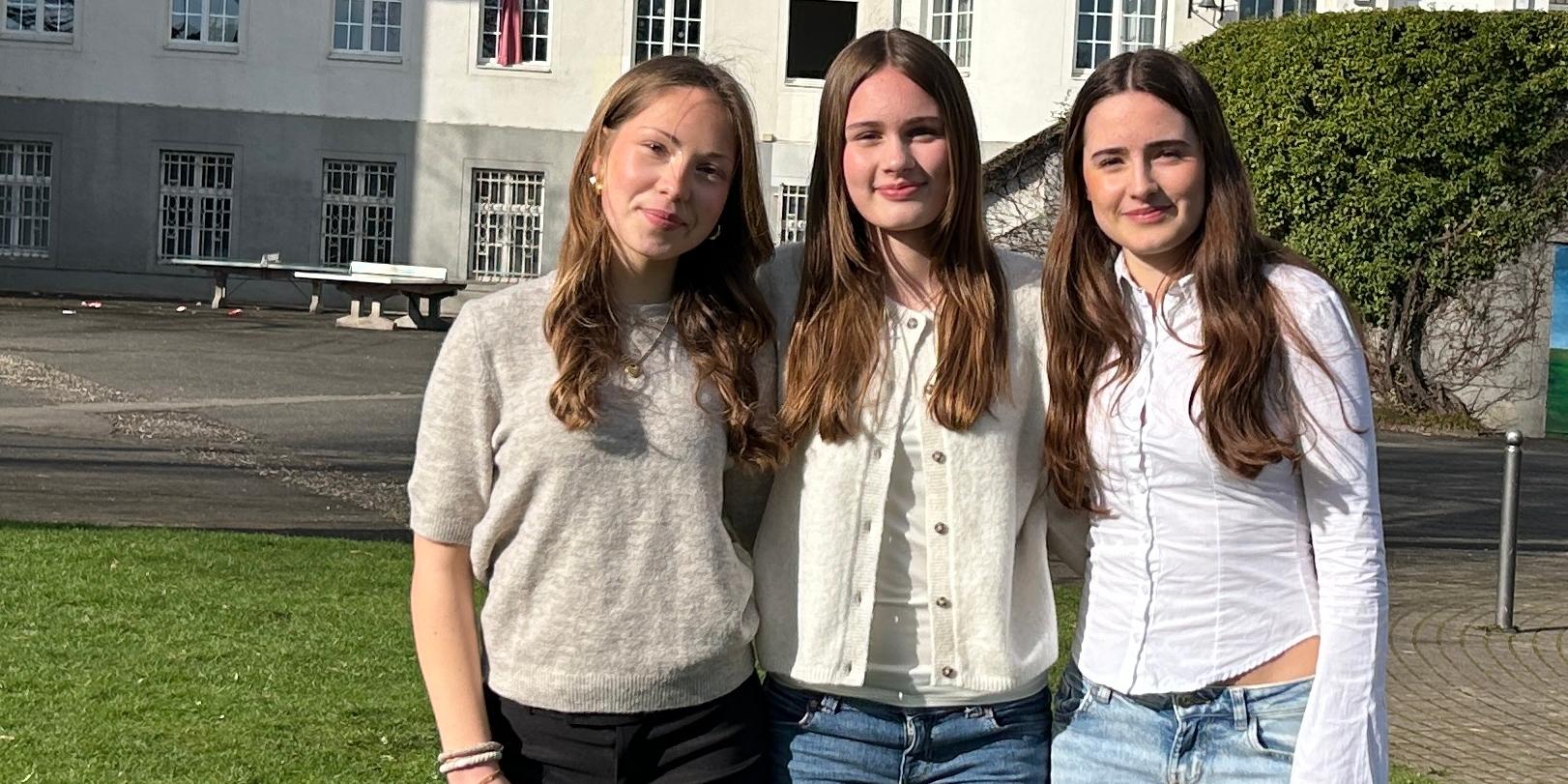 drei Mädchen vor dem Schulgebäude
