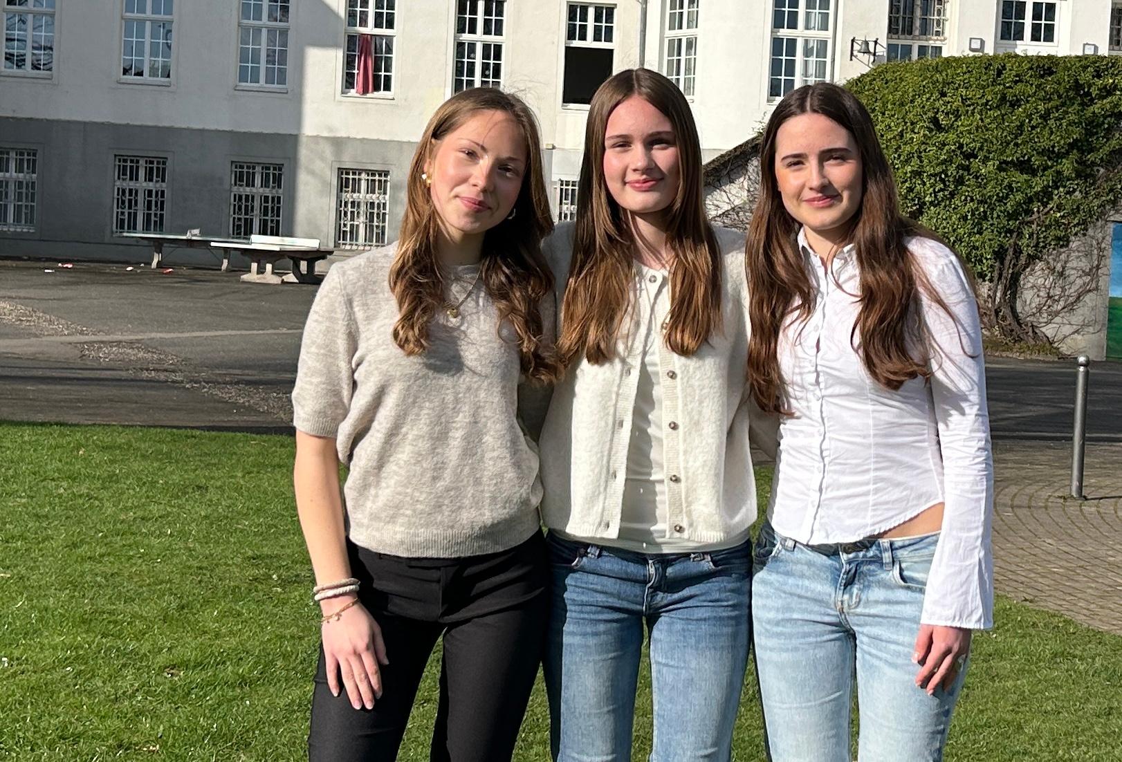 drei Mädchen vor dem Schulgebäude