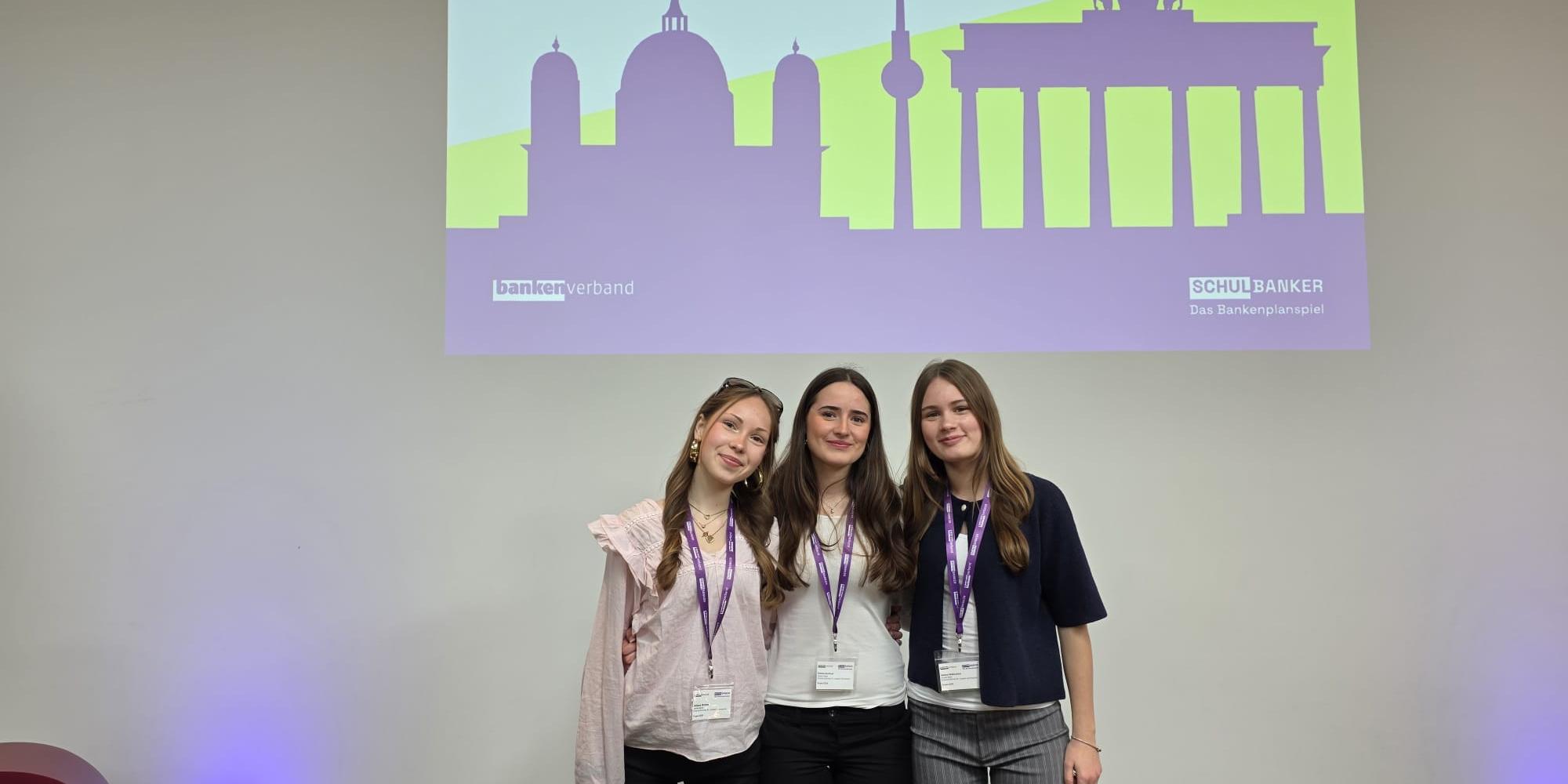 drei Mädchen, darüber Projektion: Preisverleihung 27.4.2026