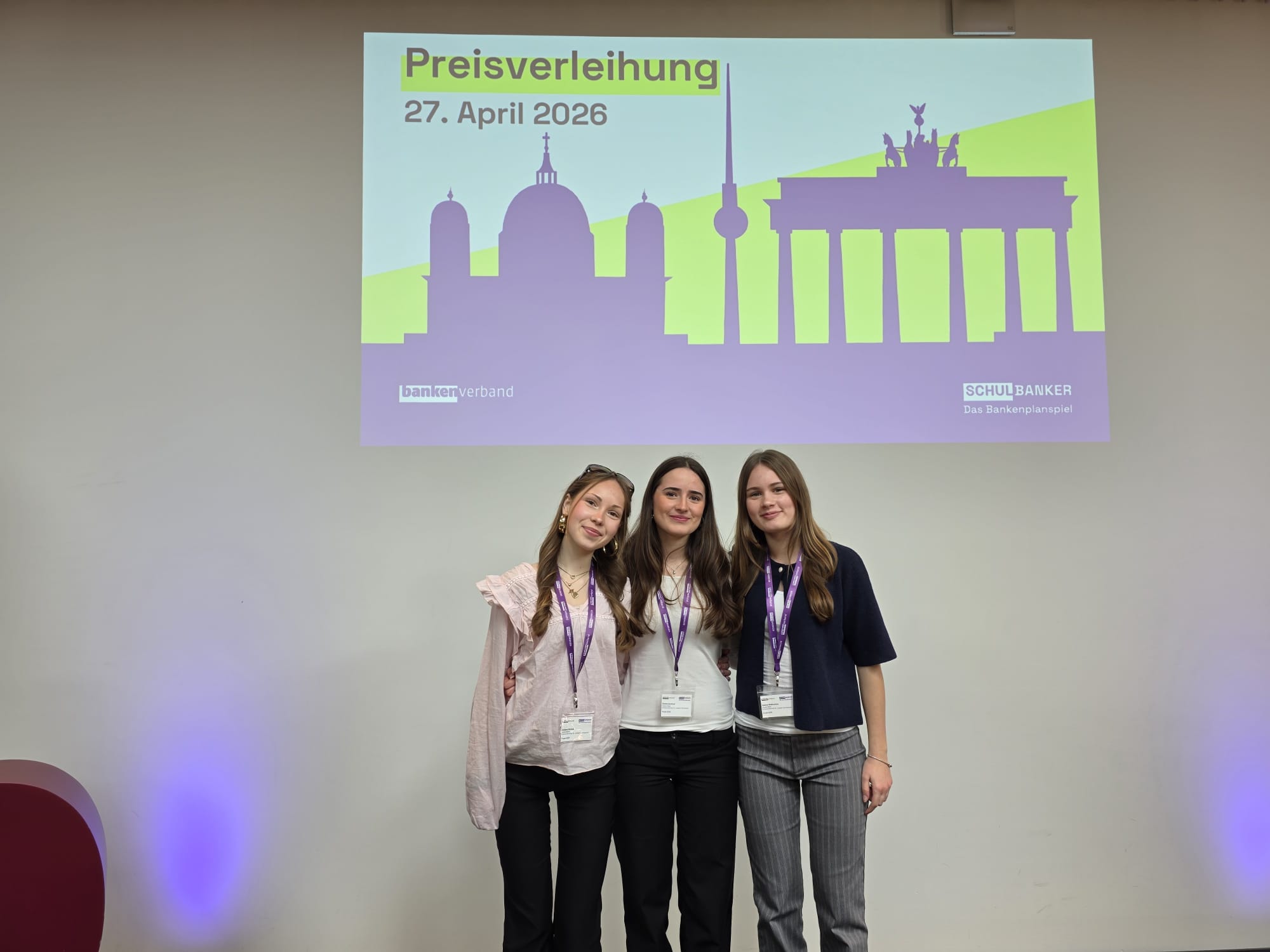 drei Mädchen, darüber Projektion: Preisverleihung 27.4.2026