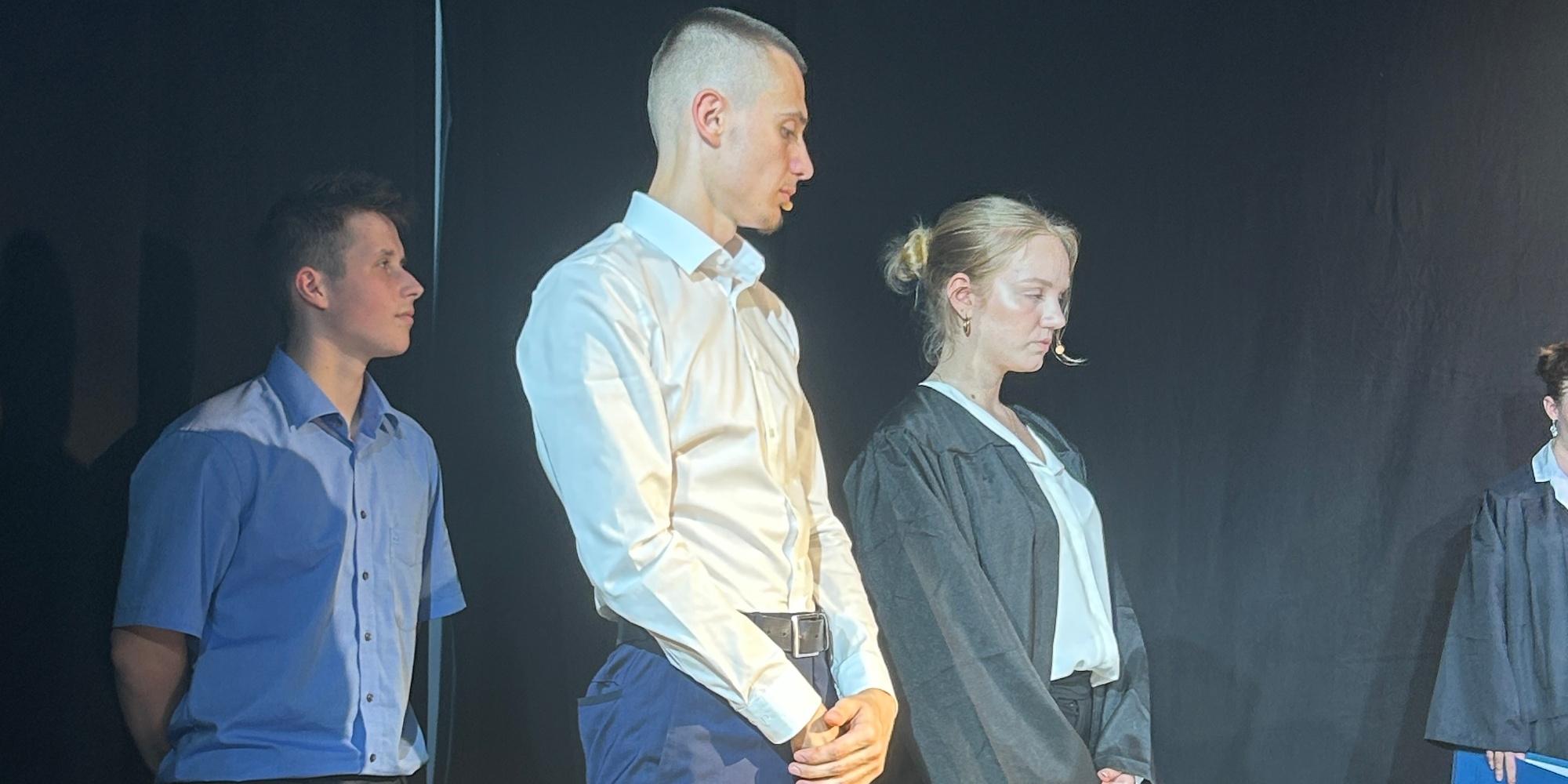 Schüler als Wächter, Schüler als Angeklagter, Schülerin als Rechtsanwältin auf der Bühne