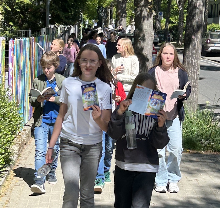 Kinder auf dem Gehweg, Taschenbücher in der Hand