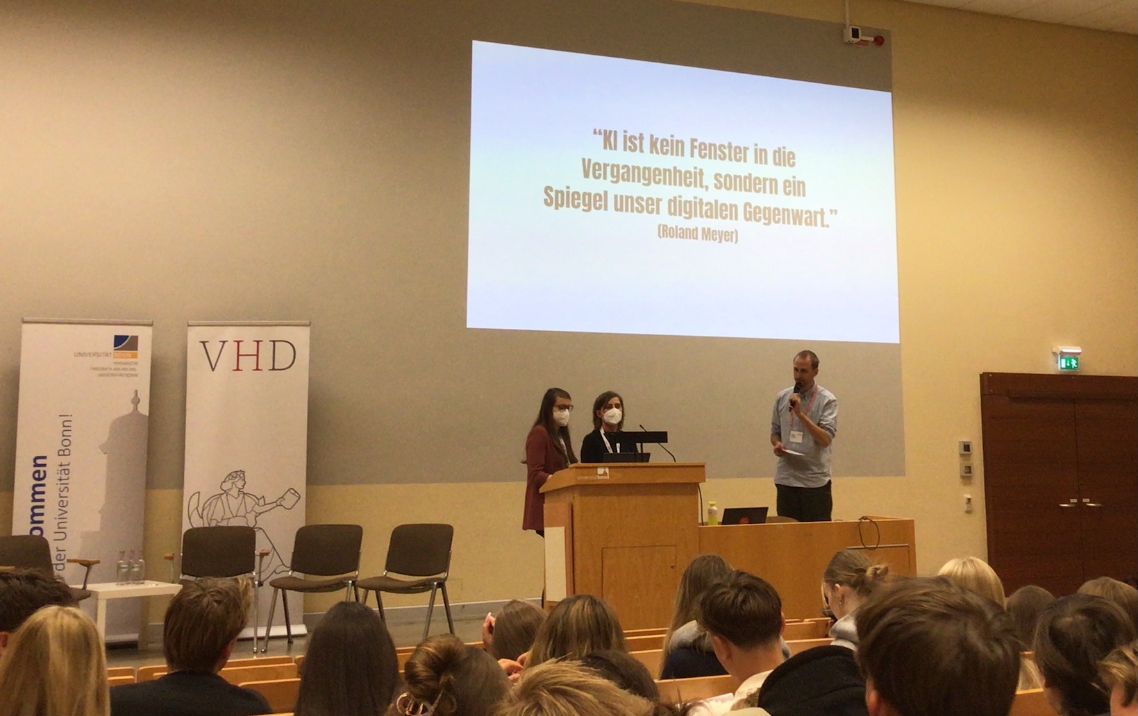 Projektion: 'KI ist kein Fenster in die Vergangenheit, sondern ein Spiegel unserer digitalen Gegenwart.' (Roland Meyer)