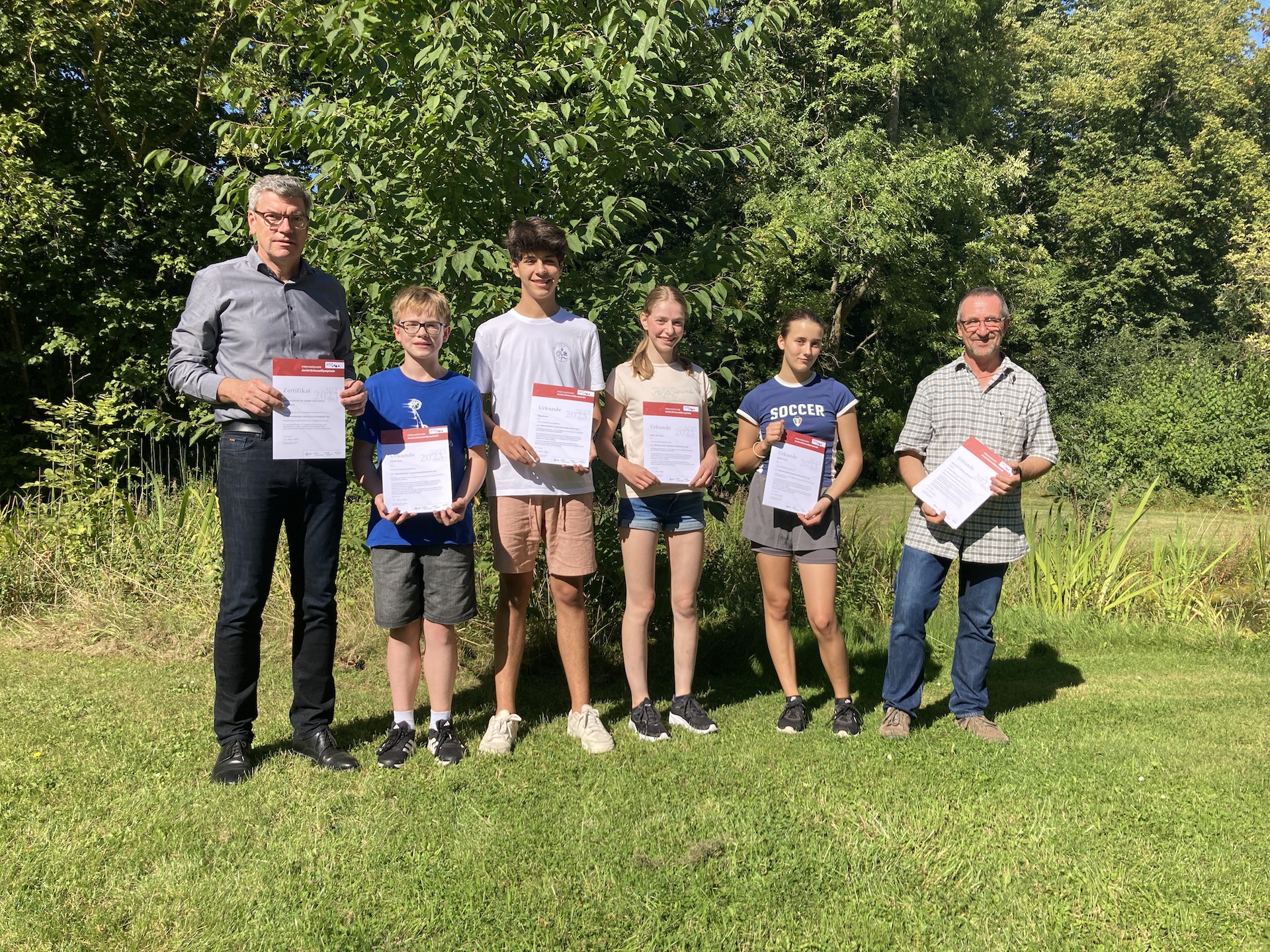 IJSO-Urkunden Jakob Viola, Silas Worm, Julina Bildstein und Sophie Kelter. Dr. Helmut Gaßmann und Schulleiter Michael Bornemann am Rand