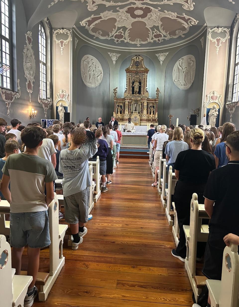 Priester am Altar, Schülerinnen und Schüler in Kirchenbänken (c) SJG Rheinbach Priester am Altar, Schülerinnen und Schüler in Kirchenbänken