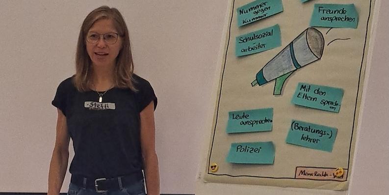 Frau vor einem Flipchart, darauf Stichpunkte zu Kinderrechten