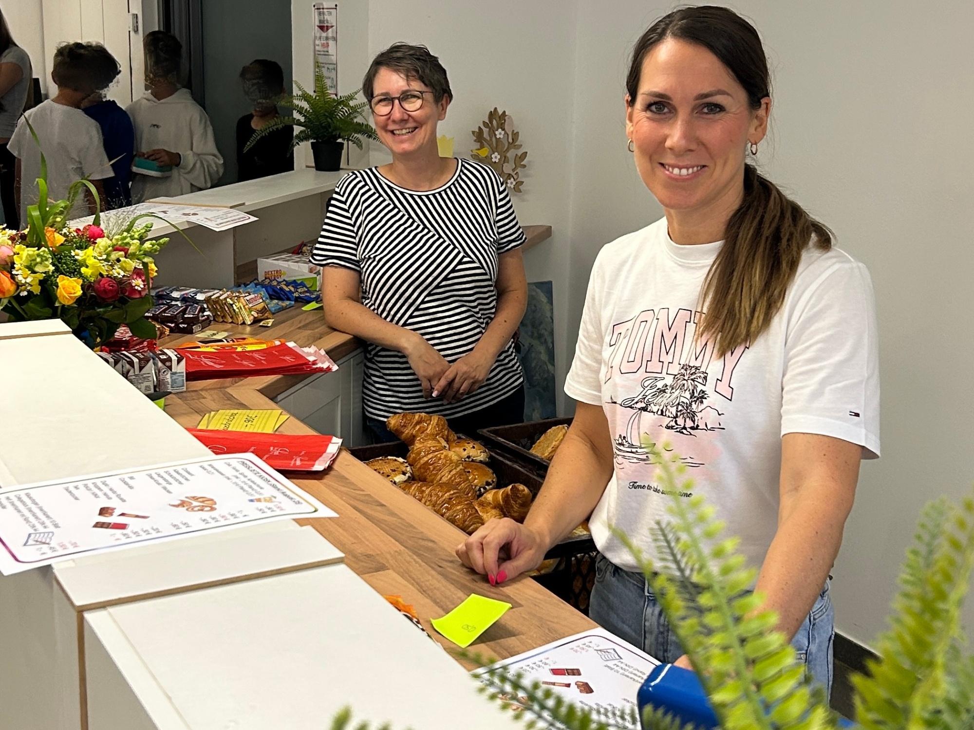zwei Frauen hinter einer Theke, Croissants, Preisliste