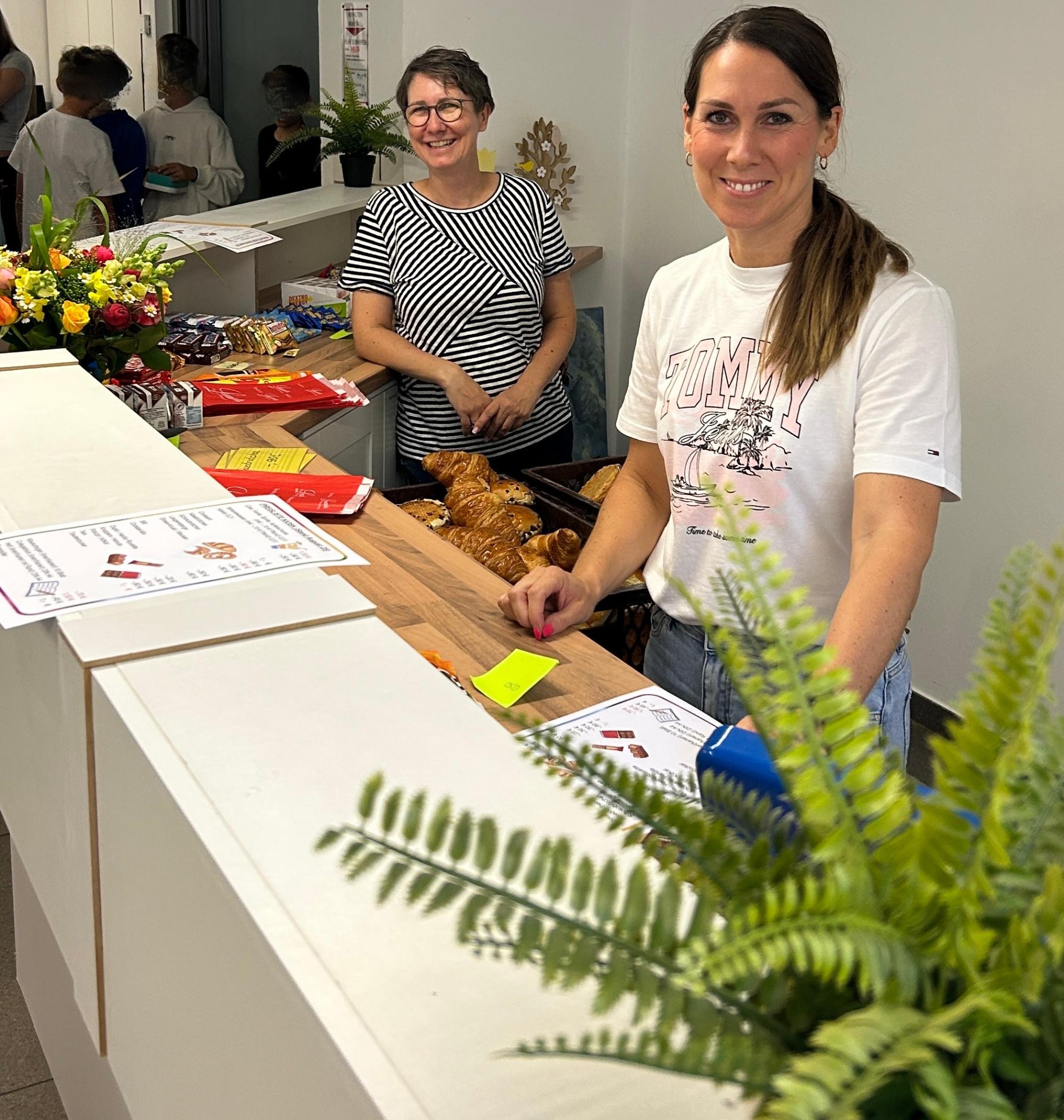 zwei Frauen hinter einer Theke, Croissants, Preisliste