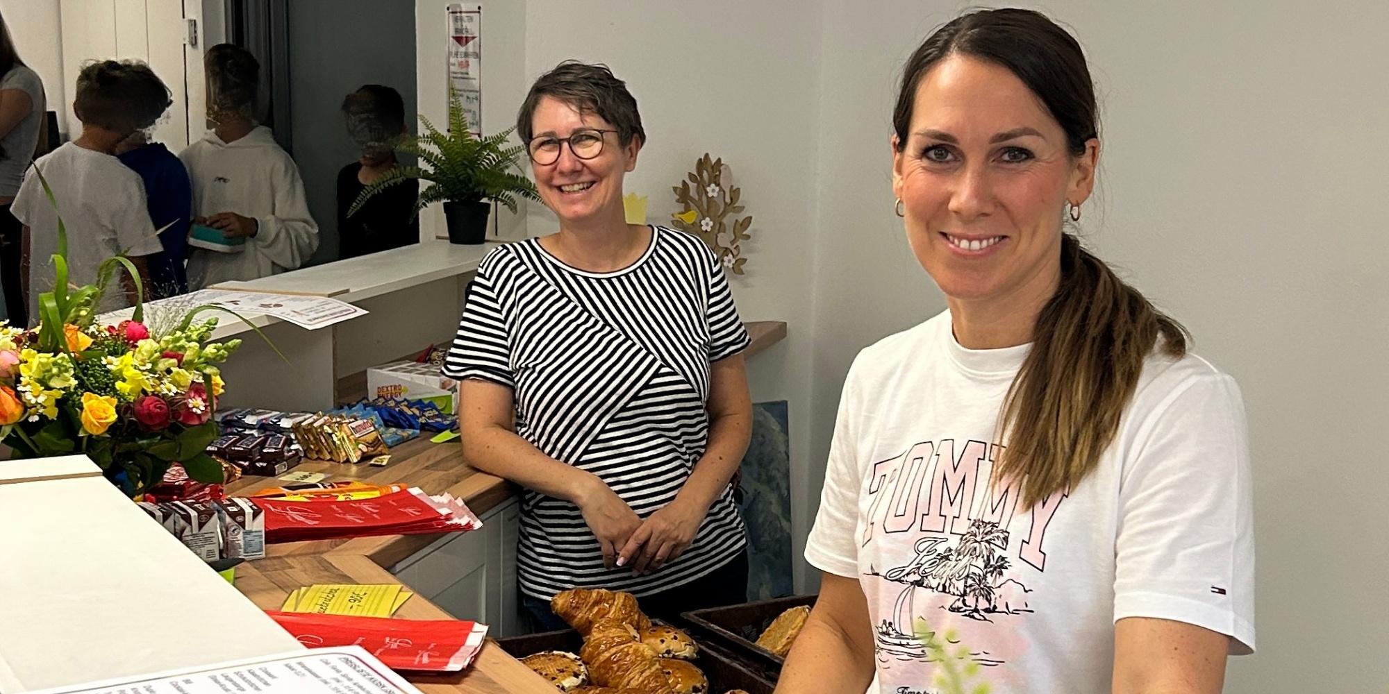zwei Frauen hinter einer Theke, Croissants, Preisliste