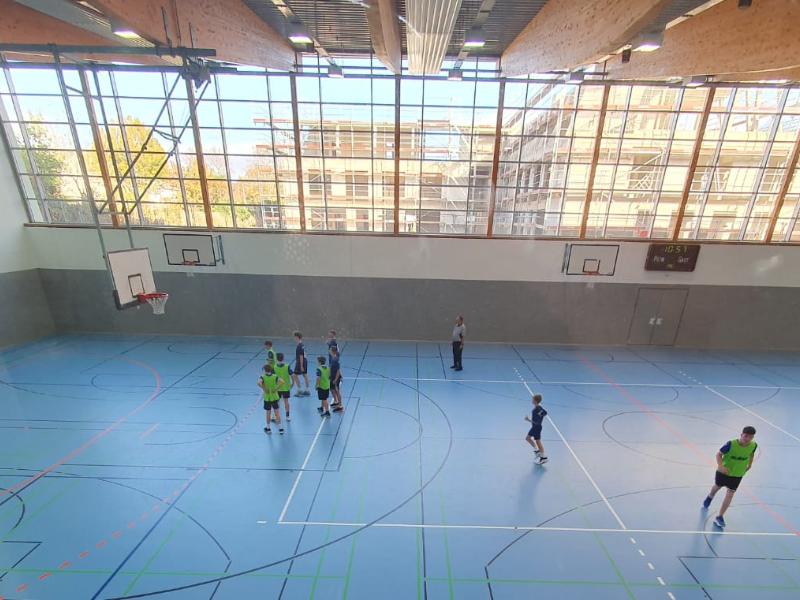 Jungen spielen Basketball, Blick von oben in die Halle