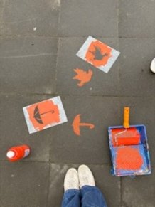 auf Asphalt gesprühte Schirme und eine Taube