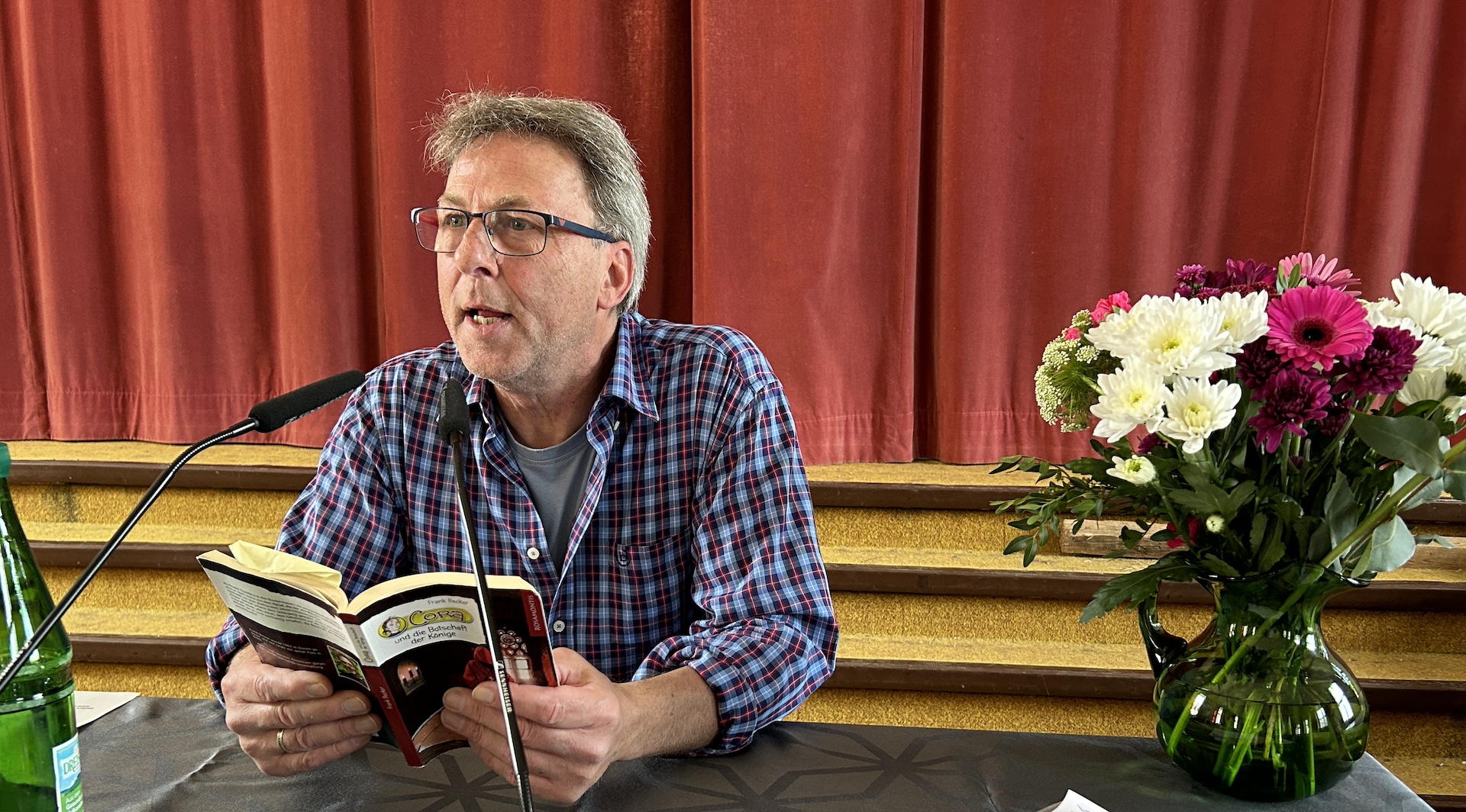 Frank Becker liest aus einem Buch vor