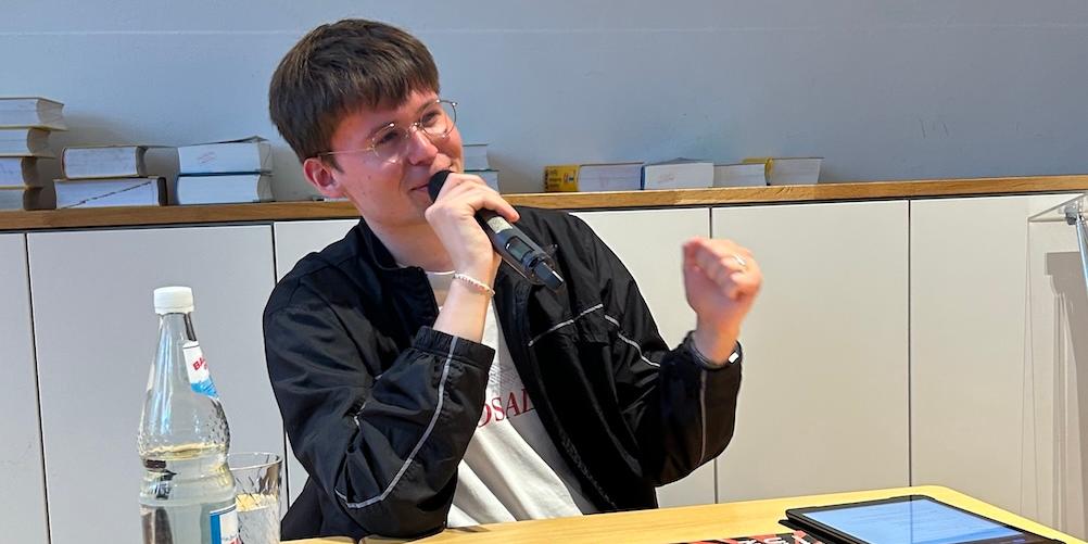Junger Mann spricht (zu einem Publikum)