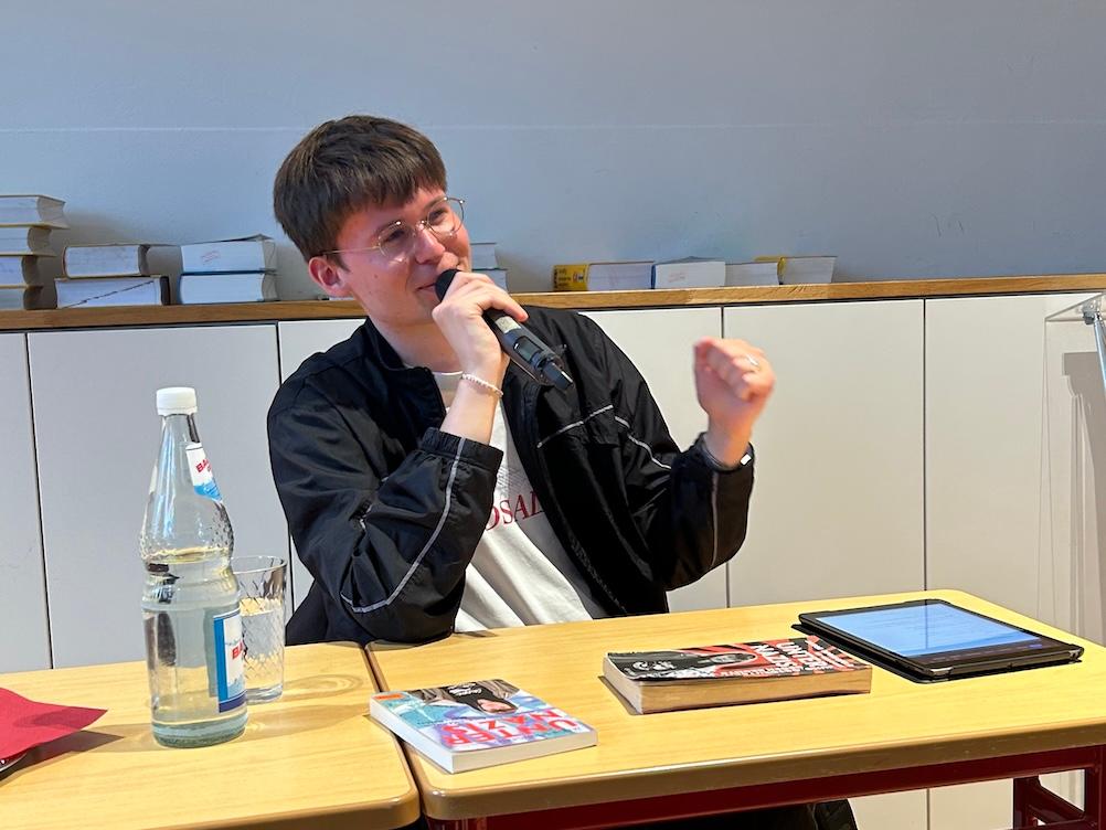 Junger Mann spricht (zu einem Publikum)
