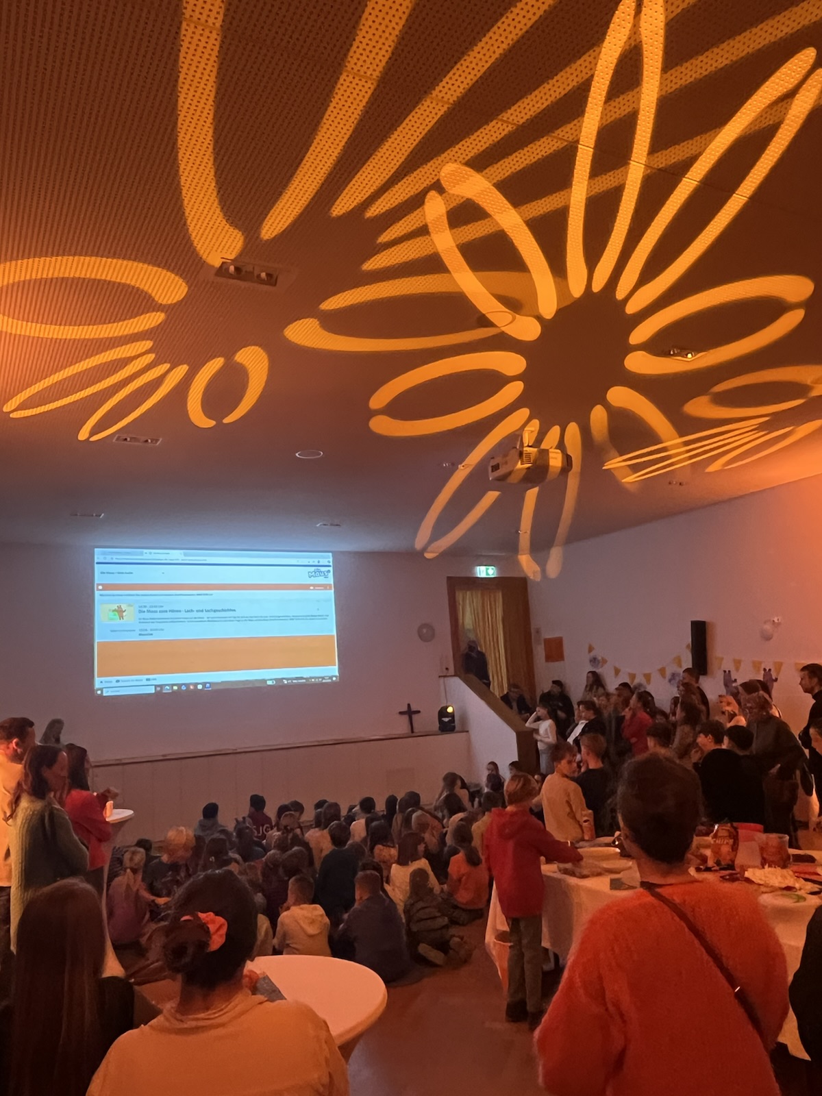 Blick auf digitales Bord mit Webpage WDR-Maus-Sendung, orange Blumen an der Decke projiziert