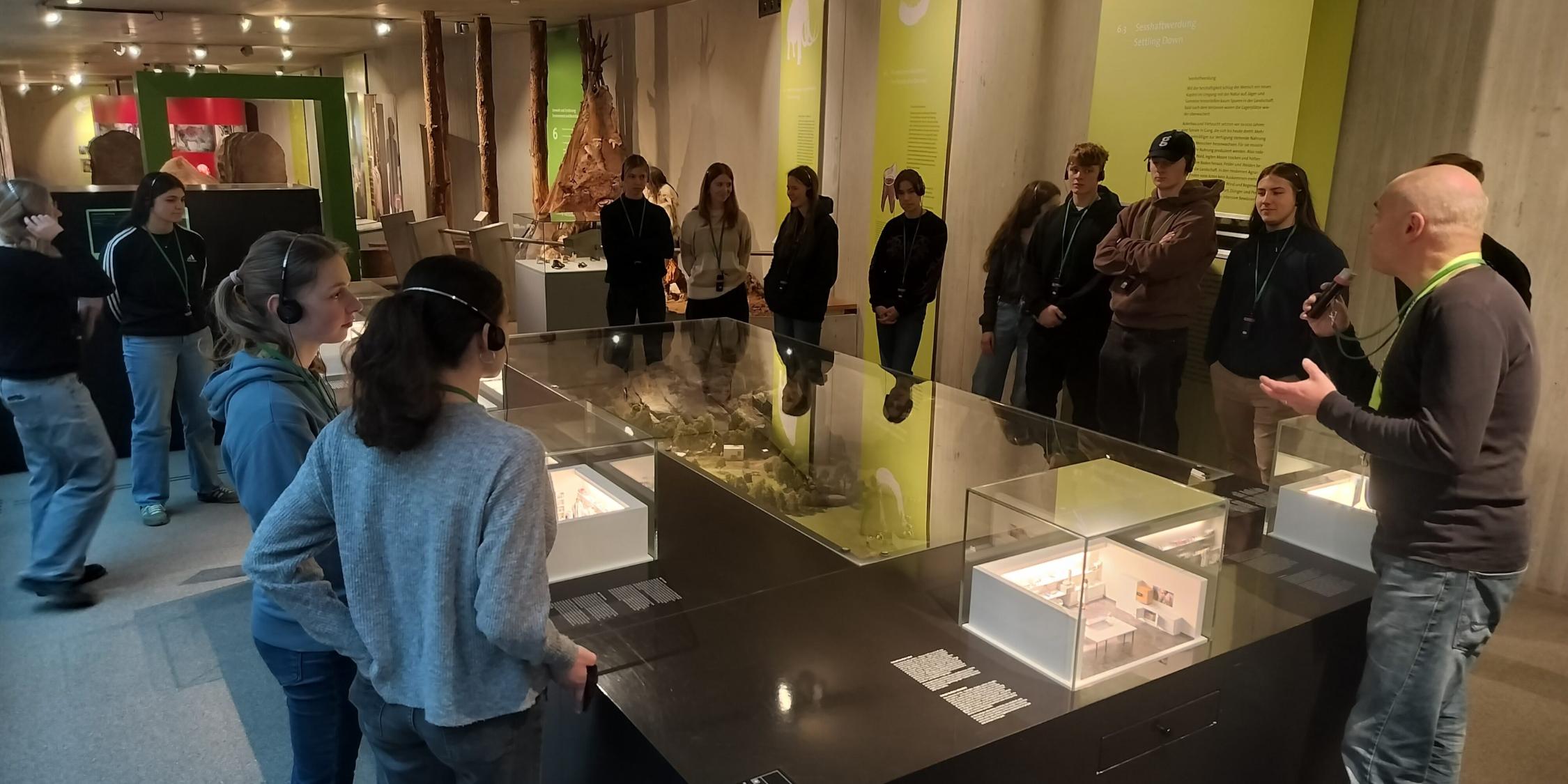 Schülerinnen und Schüler stehen um einen großen Schaukasten