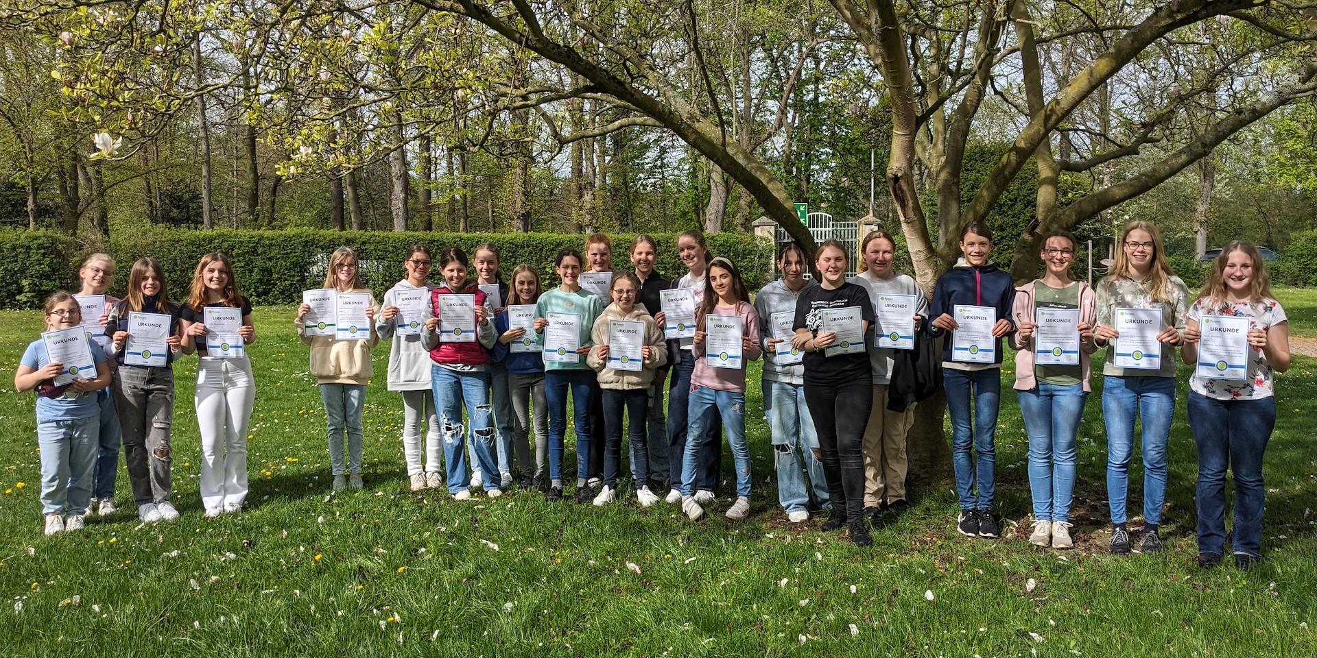 Mädchen mit Urkunden im Schulpark