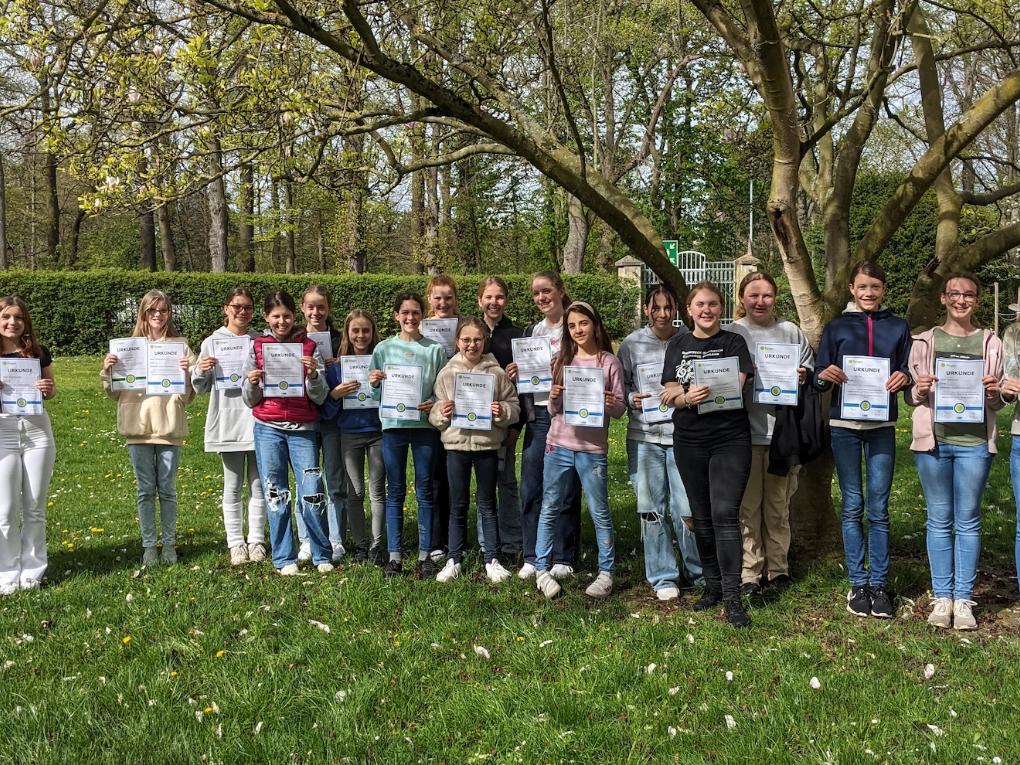 Mädchen mit Urkunden im Schulpark