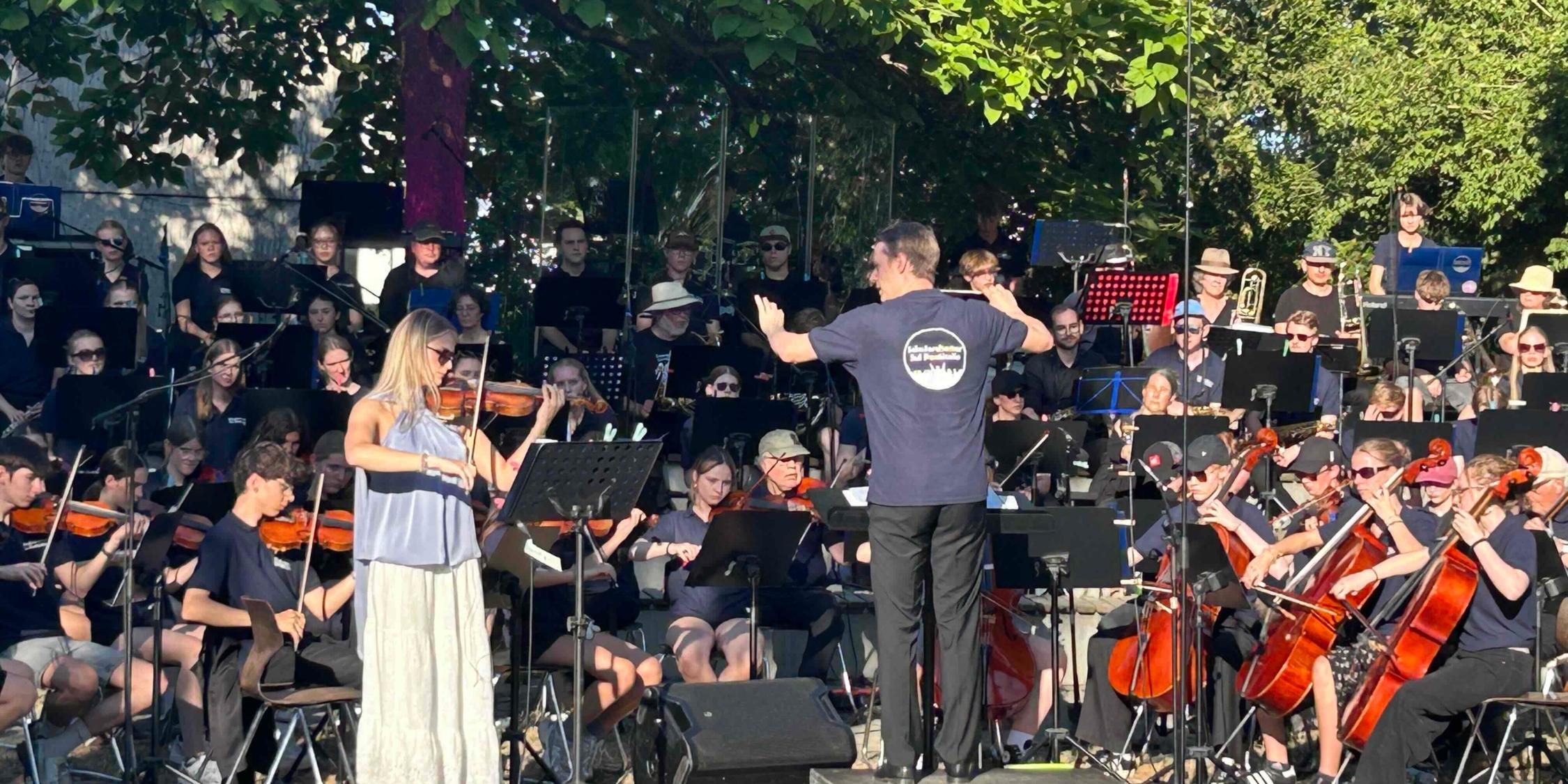 Orchester, Dirigent Solistin unter Bäumen