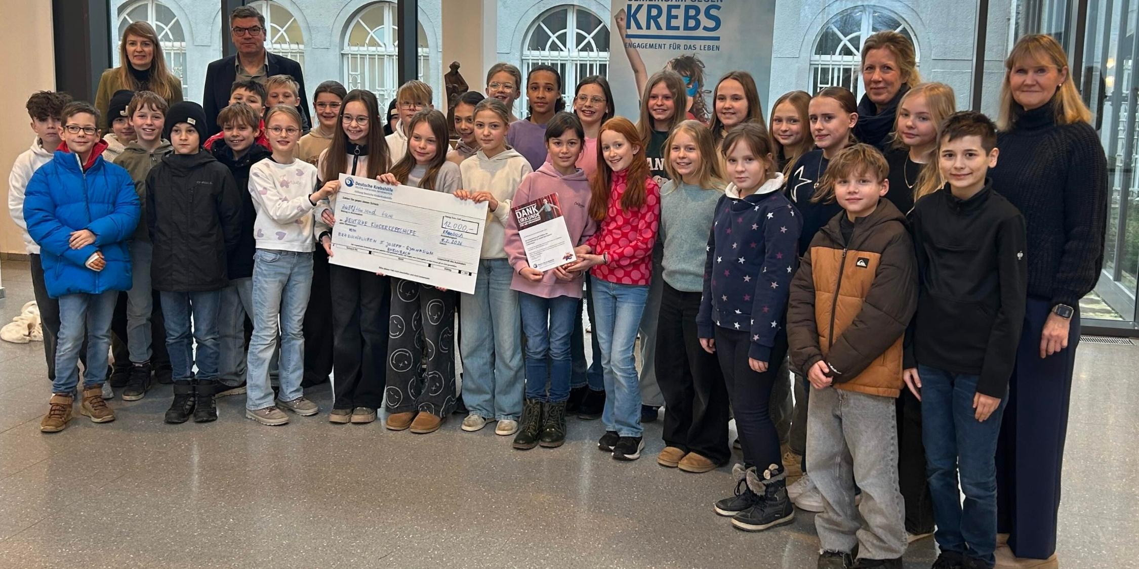 Gruppenfoto mit Kindern und Erwachsene, im Vordergrund ein großer Scheck