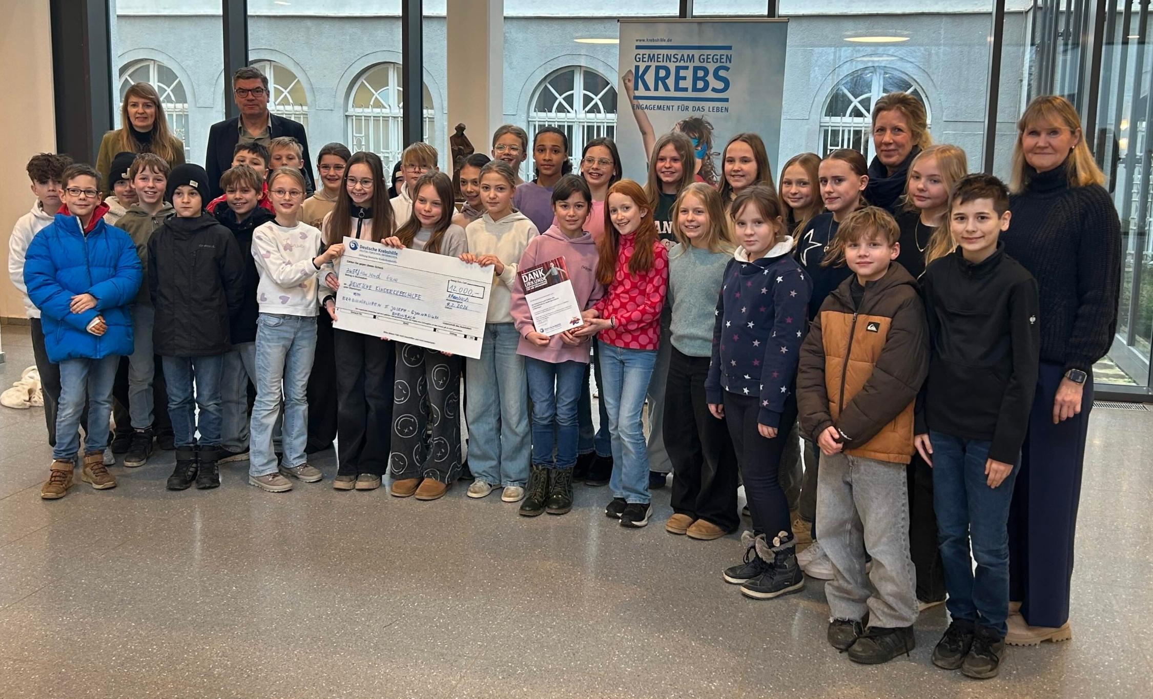 Gruppenfoto mit Kindern und Erwachsene, im Vordergrund ein großer Scheck