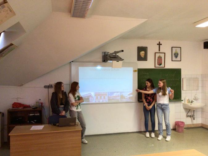 Schülerinnen vor einer Leinwand bei einer Präsentation über unsere Schule