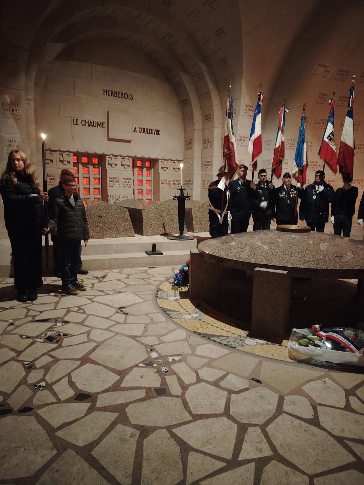 Schülerin trägt Fackel, rechts daneben Schüler, auf der anderen Seite Soldaten mit französischen Flaggen