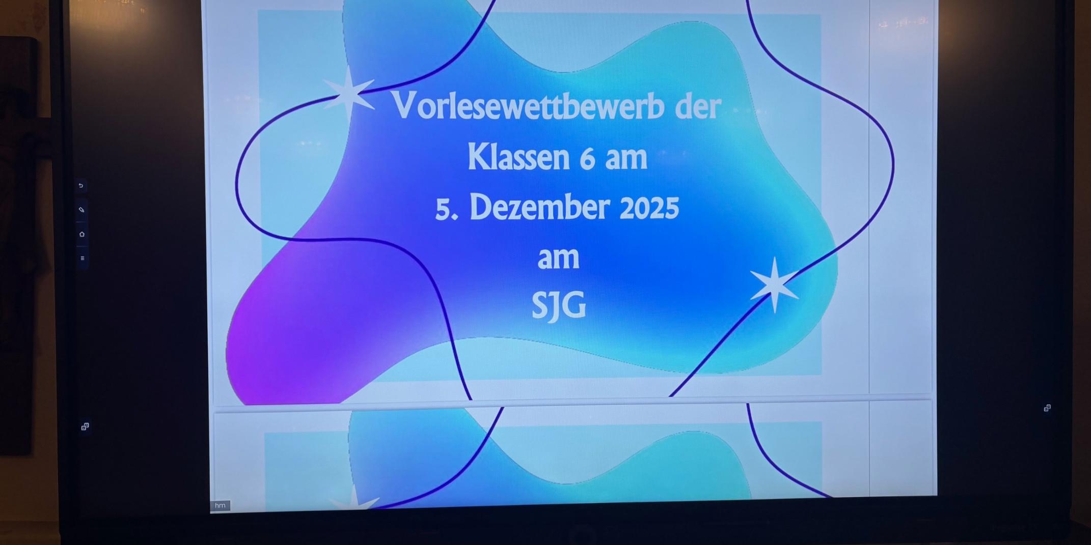 Monitor mit der Schrift 'Vorlesewettbewetb Klassen 6, 5. Dezember 2025 am SJG'