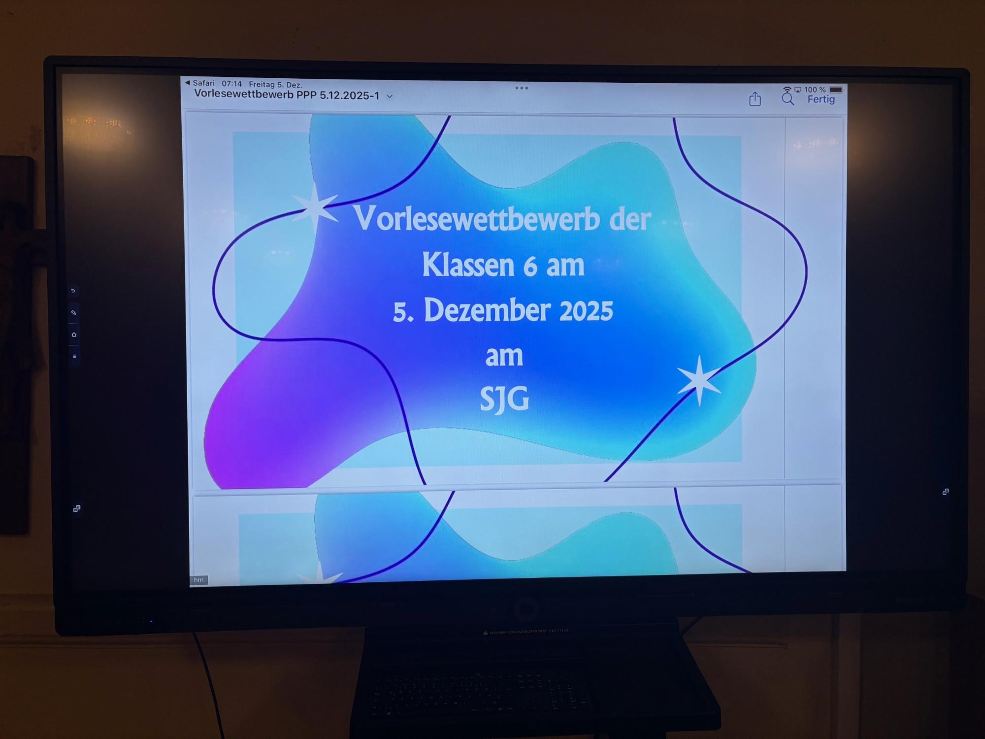 Monitor mit der Schrift 'Vorlesewettbewetb Klassen 6, 5. Dezember 2025 am SJG'