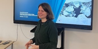 Frau vor Bildschirm stehend (Präsentationstitel 'Arktis'