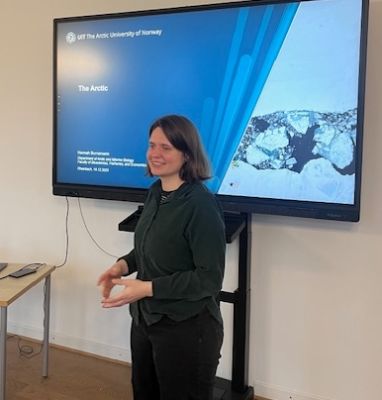 Frau vor Bildschirm stehend (Präsentationstitel 'Arktis'