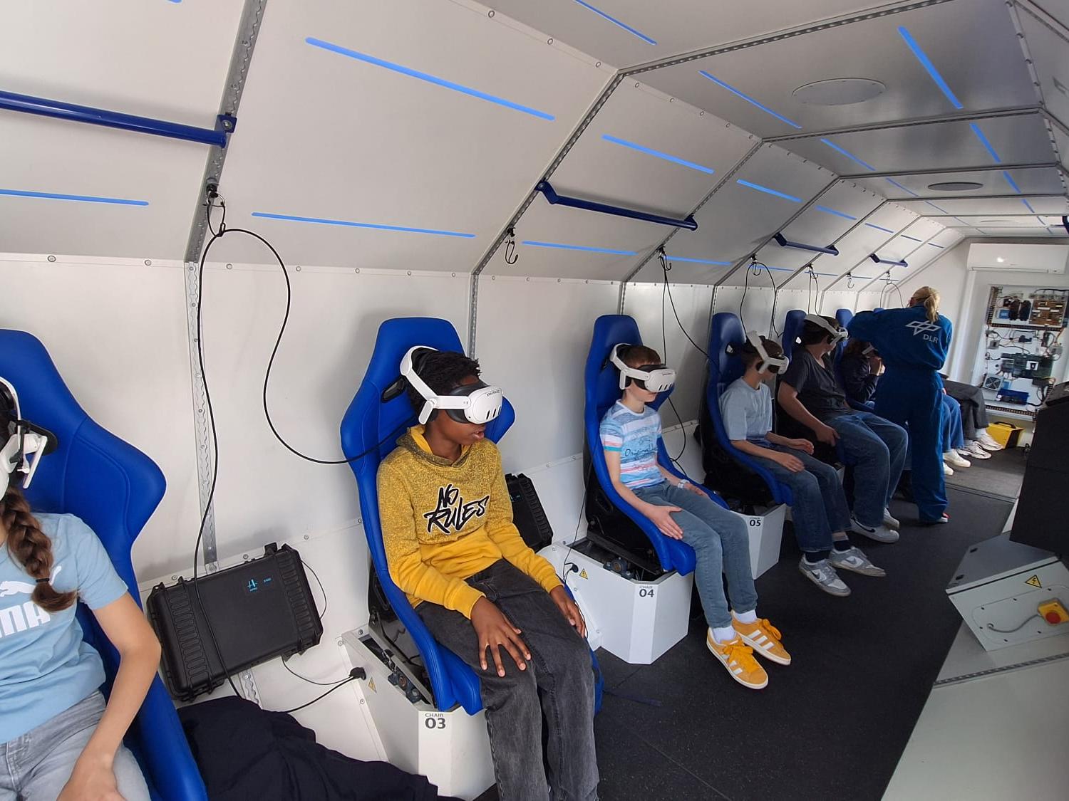 Kinder sitzen in einer nachgebauten Spacebuzz One mit VR-Brillen