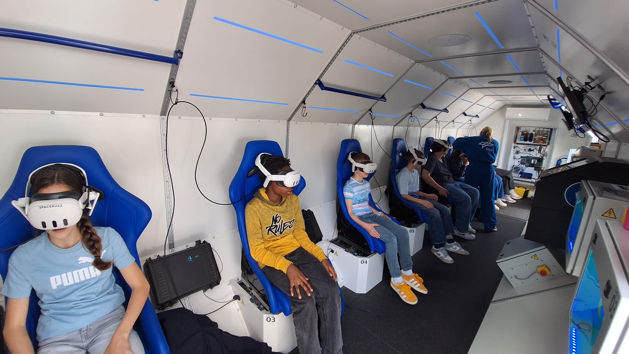 Kinder sitzen in einer nachgebauten Spacebuzz One mit VR-Brillen